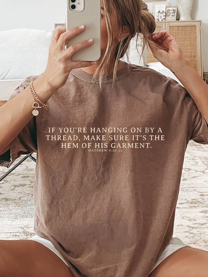 Hanging on By The Hem of His Garment Christian Graphic Tee and other Purchase Wholesale grafic tees. Free Returns & Net 60 Terms on Faire trending on Faire.