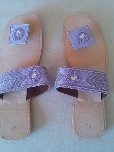 Sandale plate pour femme en couleur mauve avec semelle en cuir et détails fantaisie. pour la vente par Sandra Adrubau