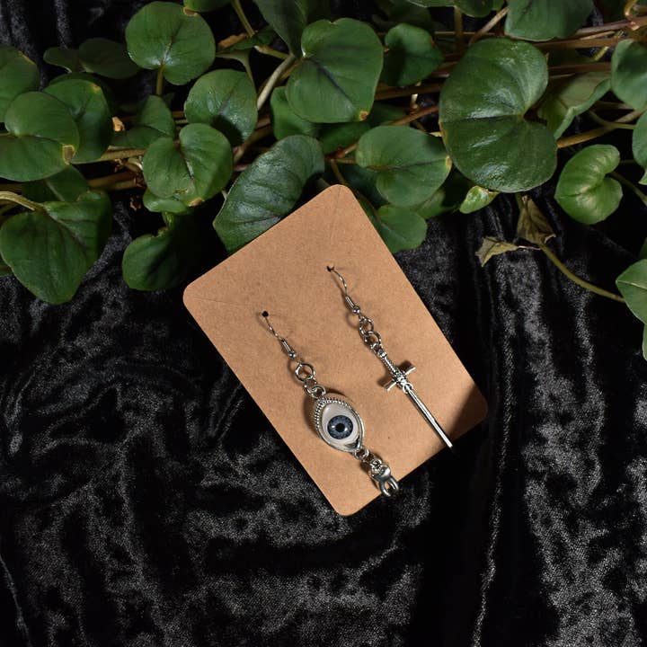 Naughty Pawsies - Wholesale Hangende/ronde oorbellen - Oorbellen met ogen en zwaard die niet bij elkaar passen