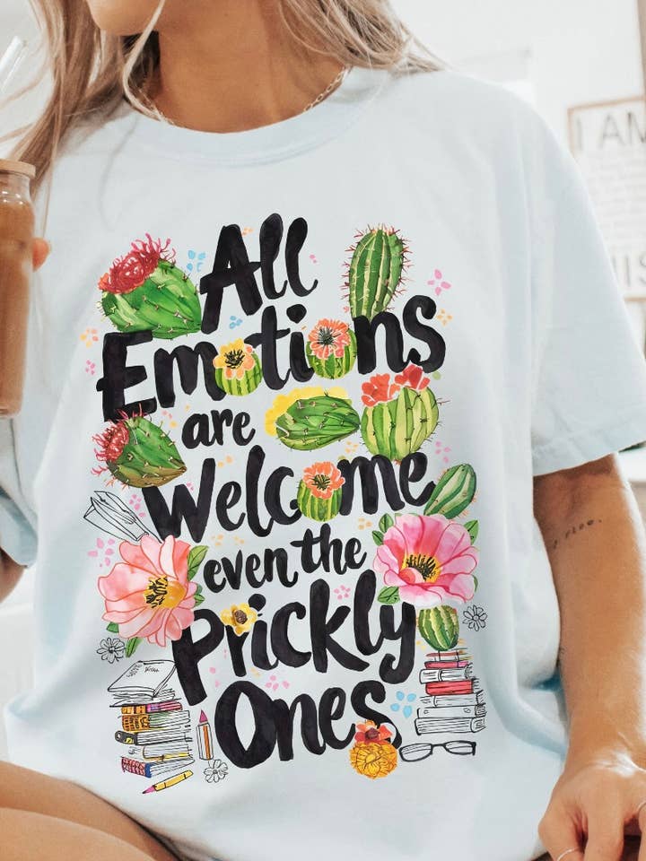 T-shirt con la scritta "Tutte le emozioni sono benvenute, anche quelle pungenti". per la vendita all'ingrosso da parte di Home Scape Plus