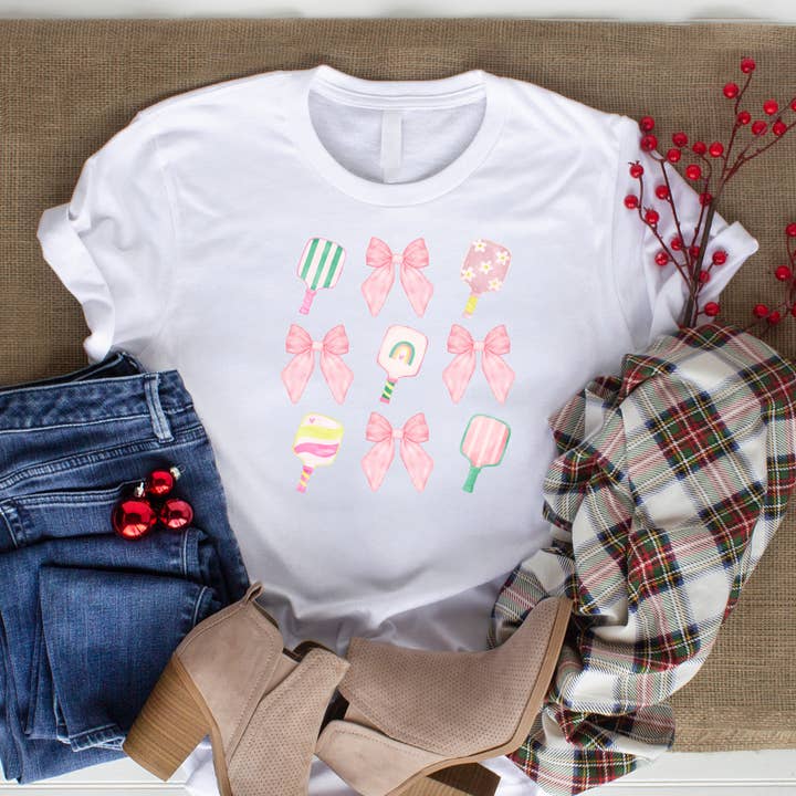 Chemise avec nœuds coquette pour enfants et raquettes de pickleball pour la vente par The Landing @ Fusion