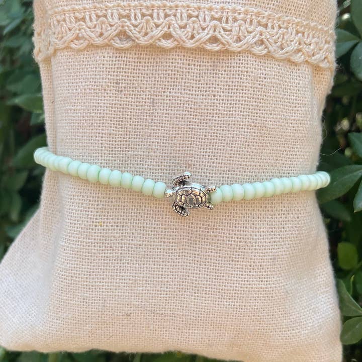 Pastelgroene enkelketting met kaurischelpen en zeeschildpad voor wholesale door Boutique Bohème