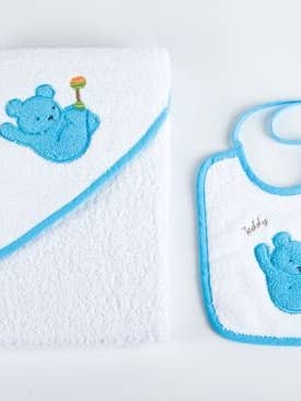 Baby bath cape and bib set on white background with Teddy bear design and blue trim for wholesale by Sandra Adrubau