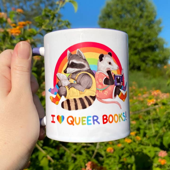 "I ♥️ Queer Books!" Reading Raccoon and Opossum Rainbow Pride 11 oz Ceramic Mug for wholesale by Allison Stoiser Art