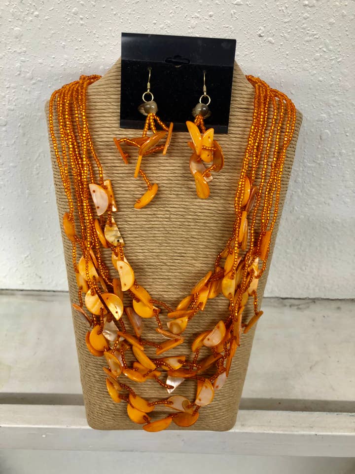 ACHT STRÄNGE ORANGEFARBENE ROCAILLEPERLEN MIT ORANGEFARBENEN HALBMONDSCHALEN für den Großhandel von International Duru's