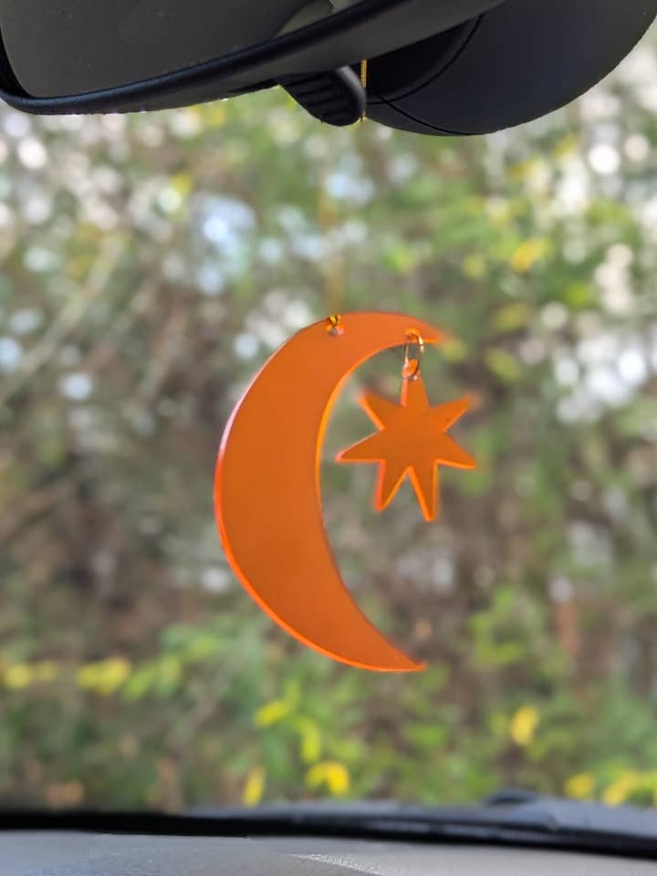 Rückspiegelanhänger: Orangefarbener Mond und Stern für den Großhandel von Savvie Studio