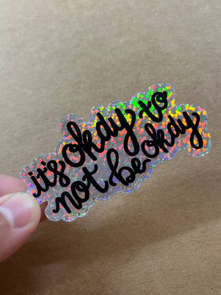 Holographic It’s Okay to Not be Okay Sticker for wholesale by ON THE GO Studio