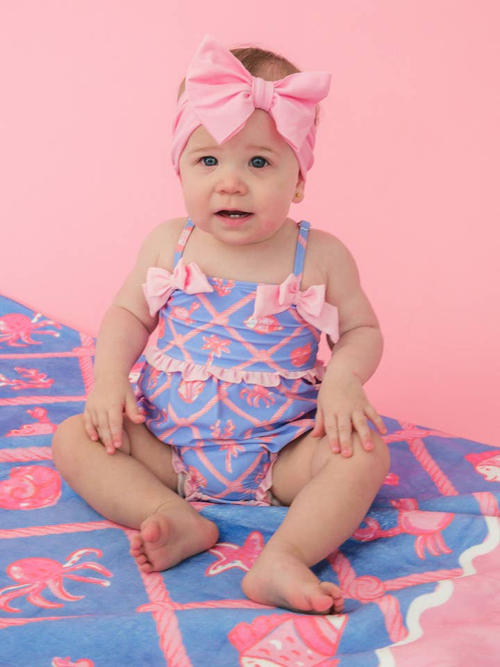 Fato de Banho de Uma Peça para Bebé Menina com Treliça Tropical e Laço, com Folhos Característicos na Parte Traseira por atacado de RuffleButts + RuggedButts