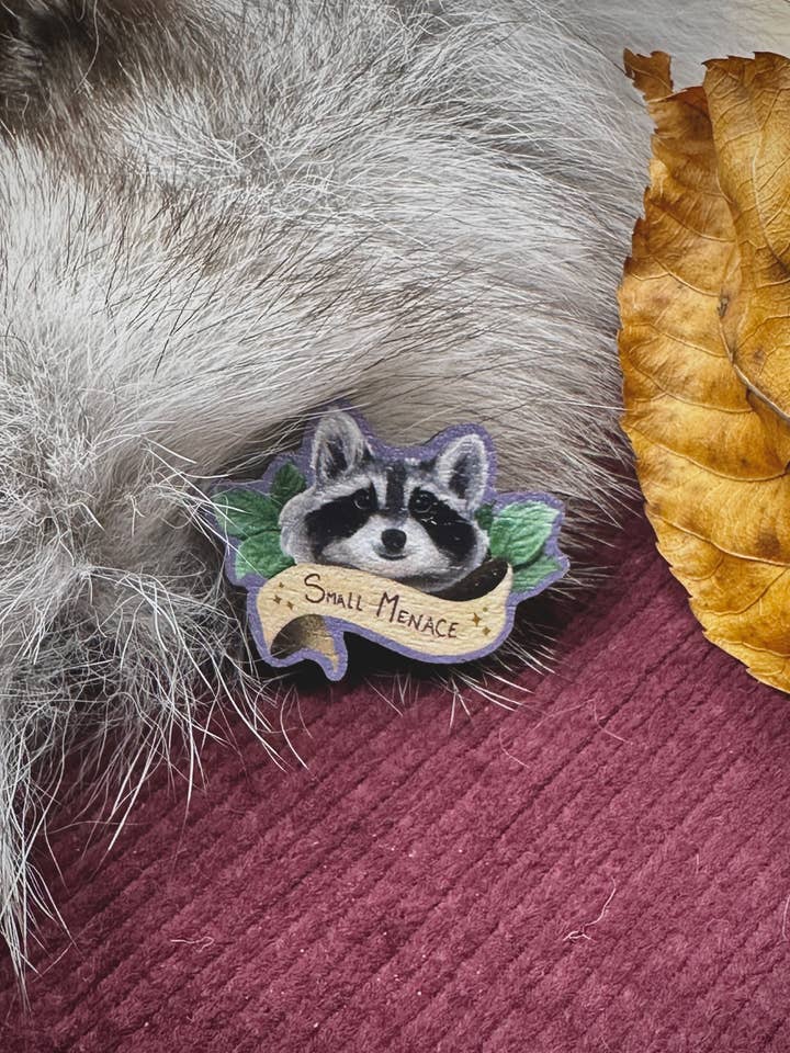 Small Menace Raccoon Wooden Pin for wholesale by Katelyn Gagnon Art