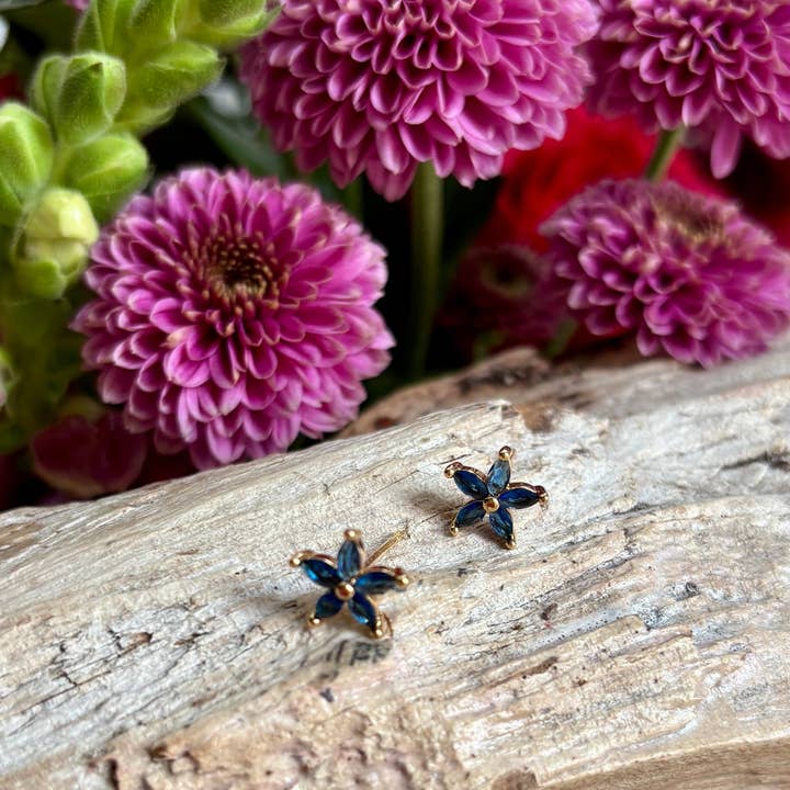 Blomformade örhängen med blå kubisk zirkonia, pläterade i 14 karat guld för wholesale av Ocean Ripples