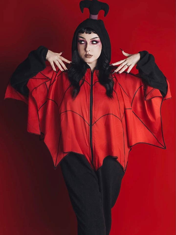 Lydia Volwassenen Onesie - Zwarte Fleece Gothic Onesie met Rode Spinrag Poncho (Kevers Geïnspireerde Editie) voor wholesale door Weasel Wear