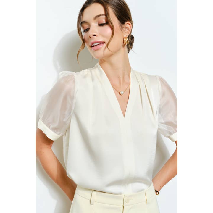 Blouse en satin à manches bouffantes transparentes avec col en V pour la vente par INA