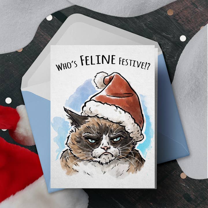 Biglietto natalizio sarcastico «Feline Festive», divertente e grumpy cat per la vendita all'ingrosso da parte di Aaron Millard Illustration