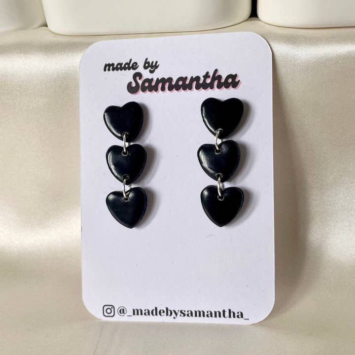 Svarta handgjorda örhängen i polymerlera med tre hängande hjärtan för wholesale av Made By Samantha