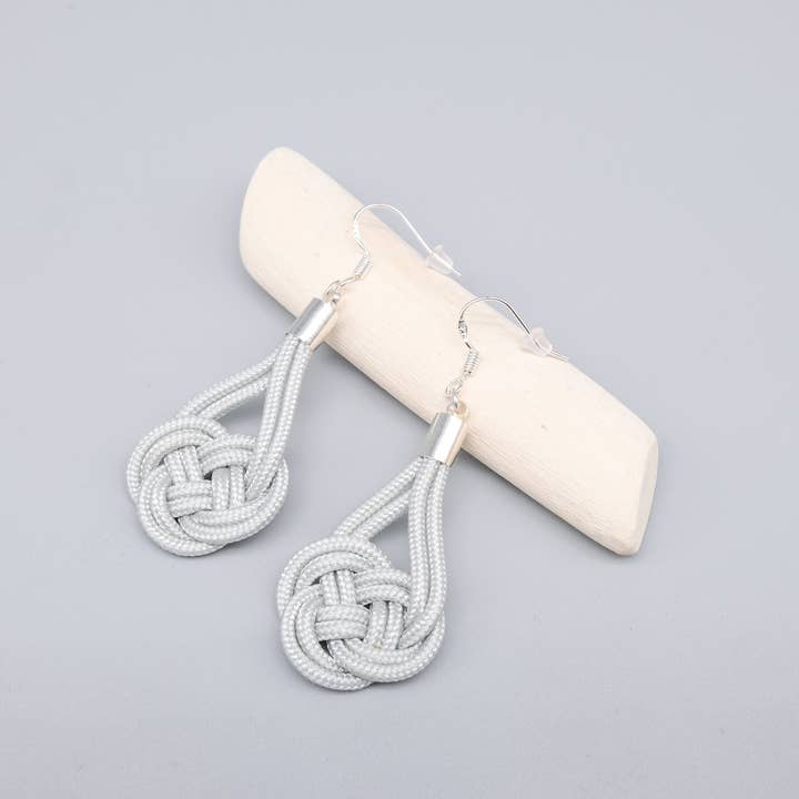 Silver örhänge i grå paracord för wholesale av La Fabrique du Noeud