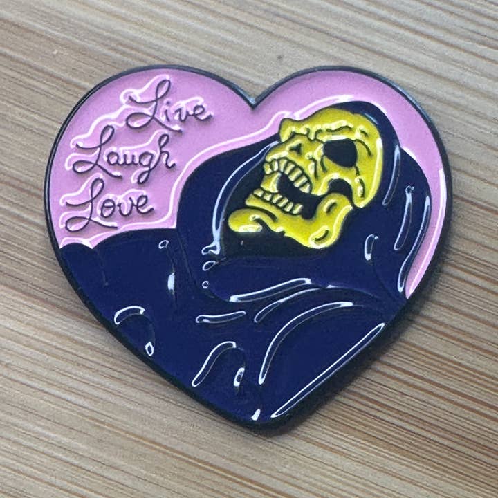 Spilla in smalto "Vivi Ridi Ama Skeletor" per la vendita all'ingrosso da parte di Scribble & Scroll