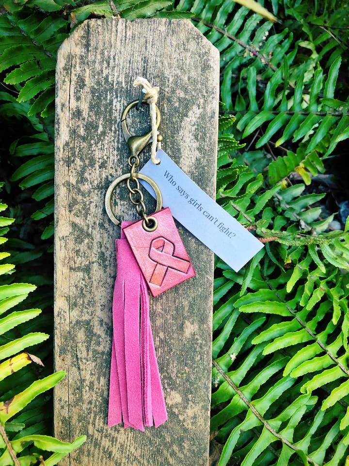 Portachiavi con nappina e targhetta Cancro al Seno per la vendita all'ingrosso da parte di Rural Roots