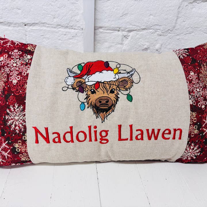Festive Highland Cow with lights - Nadolig Llawen-Merry Christmas. Red Snowflake Fabric for wholesale by Lizzie Dixon Designs