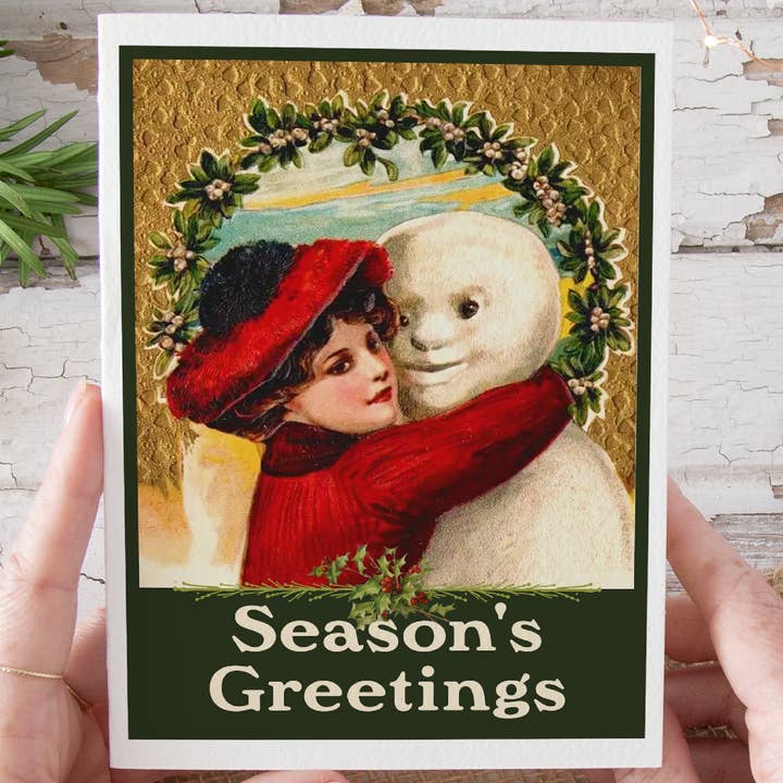 Tarjeta de Navidad Mujer vintage abrazando a un muñeco de nieve. para venta al por mayor de Cheerful Whimsies