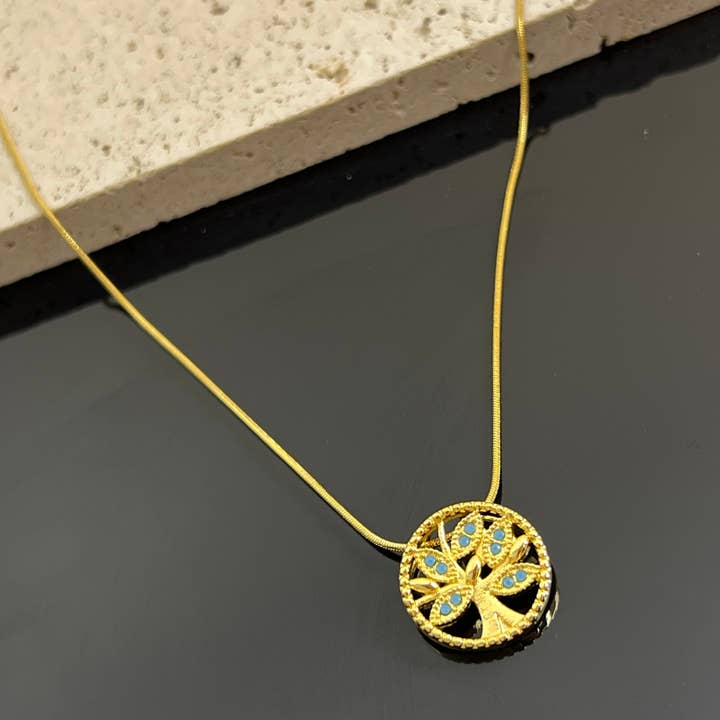 Tree of Life Necklace with small blue stone in steel and other Purchase Wholesale macro mike. Free Returns & Net 60 Terms on Faire trending on Faire.