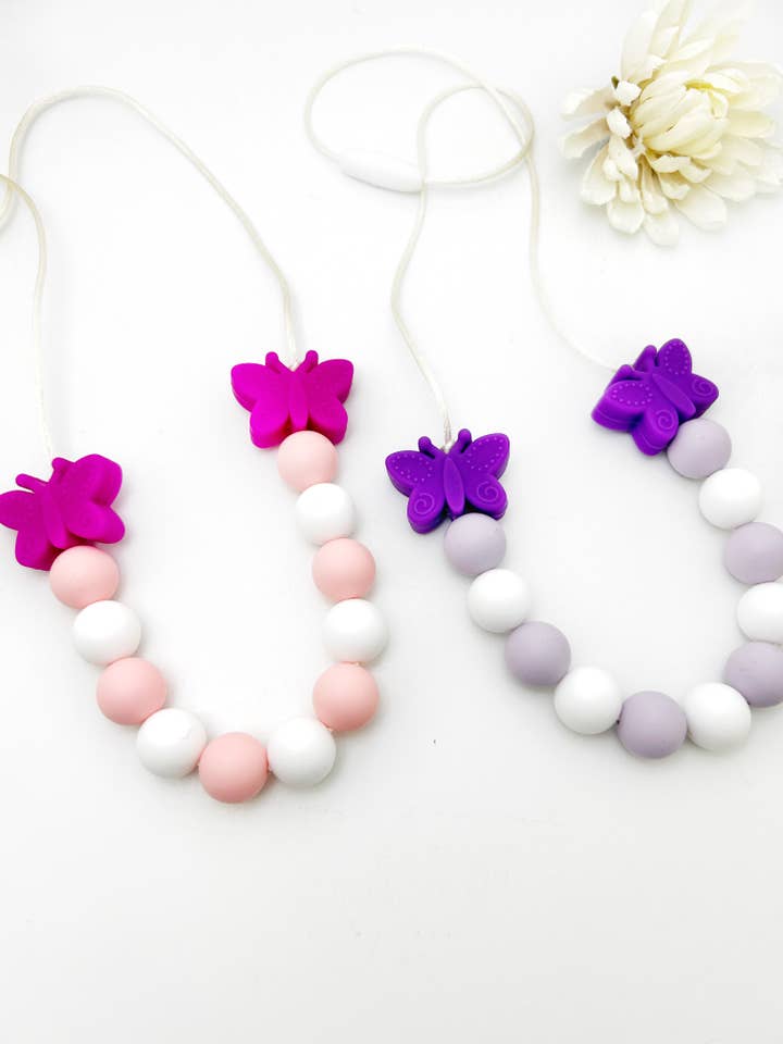 Friemelsieraden: Vlinder Sensorische Kinderketting - Kauwsieraad voor wholesale door Gummy Chic