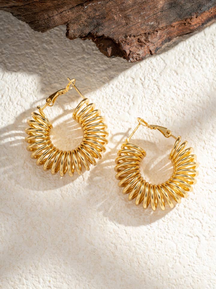 Guldfarvede spiralformede creoler i rustfrit stål – skulptureret volumen for engroshandel hos COSMOS