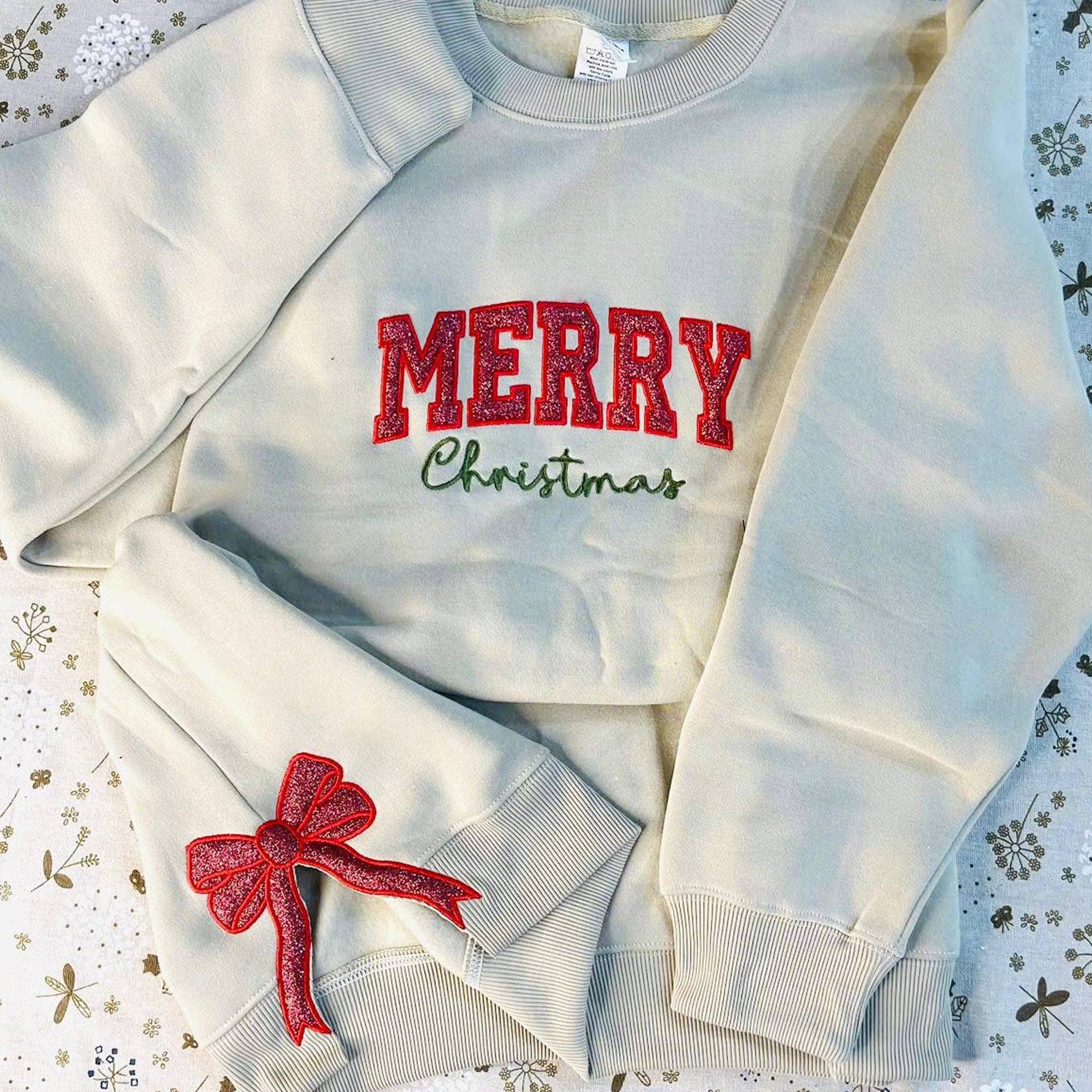 NVC Ecommerce LLC – Großhandel Sweatshirt mit Grafikdruck – Damen – Glitter Merry Xmas Red Bow, besticktes Sweatshirt mit seitlicher Schleife1