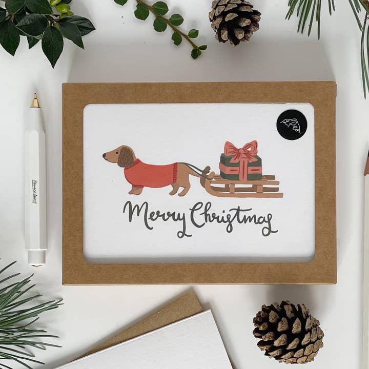 Pacote de cartões Dachshund puxando um trenó Feliz Natal por atacado de Lomond Paper Co