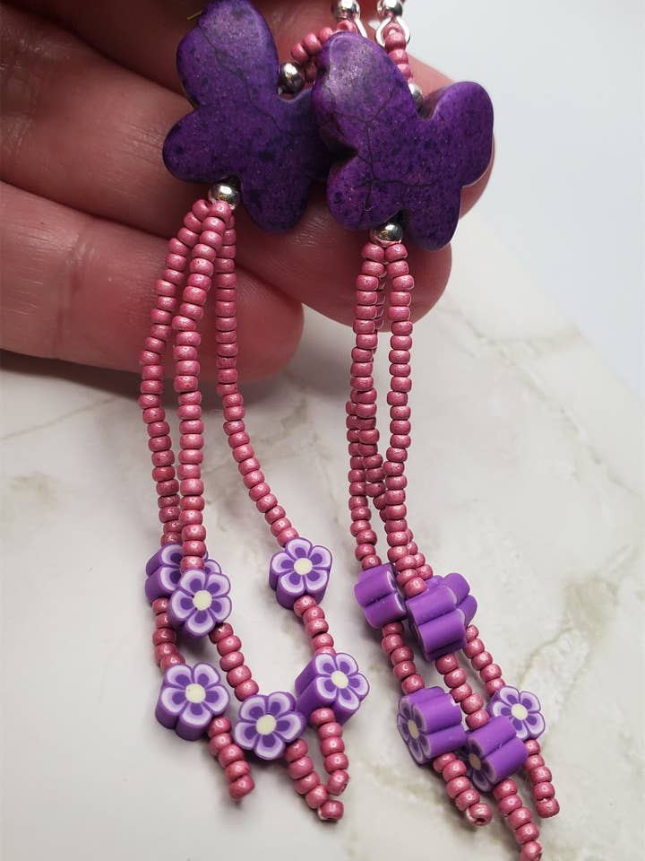 Purple Dyed Magnesite Butterfly Bead Earrings with Rose Seed Bead and Purple Fimo Clay Flower Dangles for wholesale by Simply Raevyn