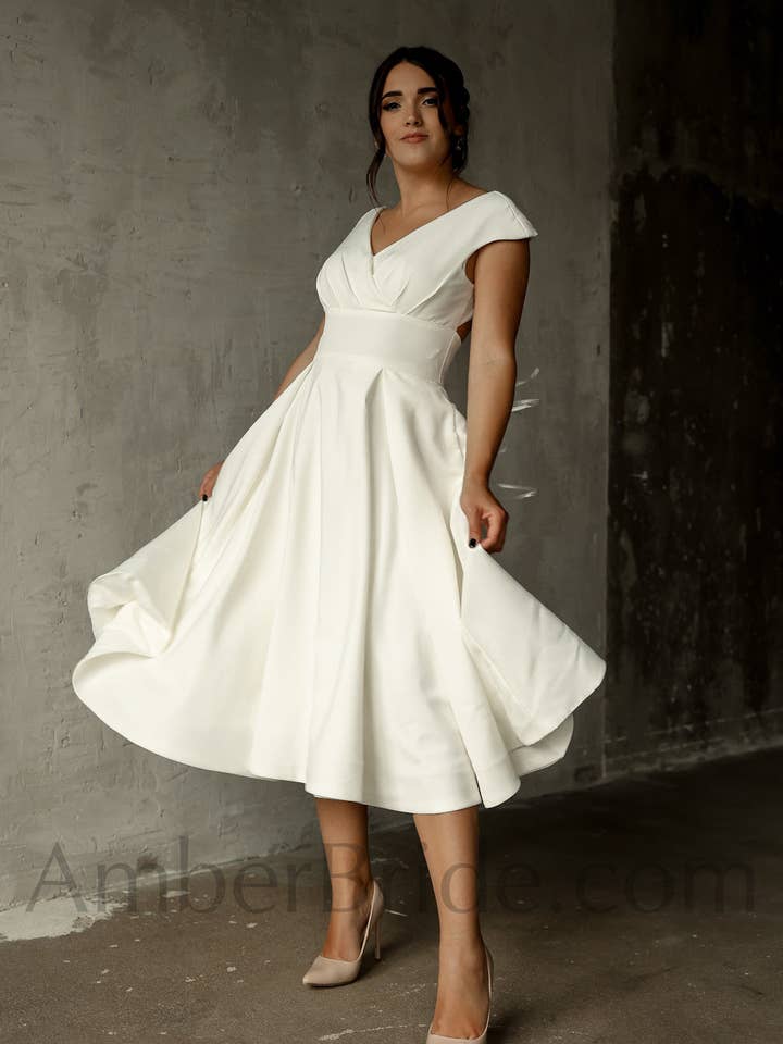 Elegante abito corto in raso a trapezio di lunghezza tè con maniche a cappuccio e schiena scoperta. per la vendita all'ingrosso da parte di Amber Commerce Group, MB