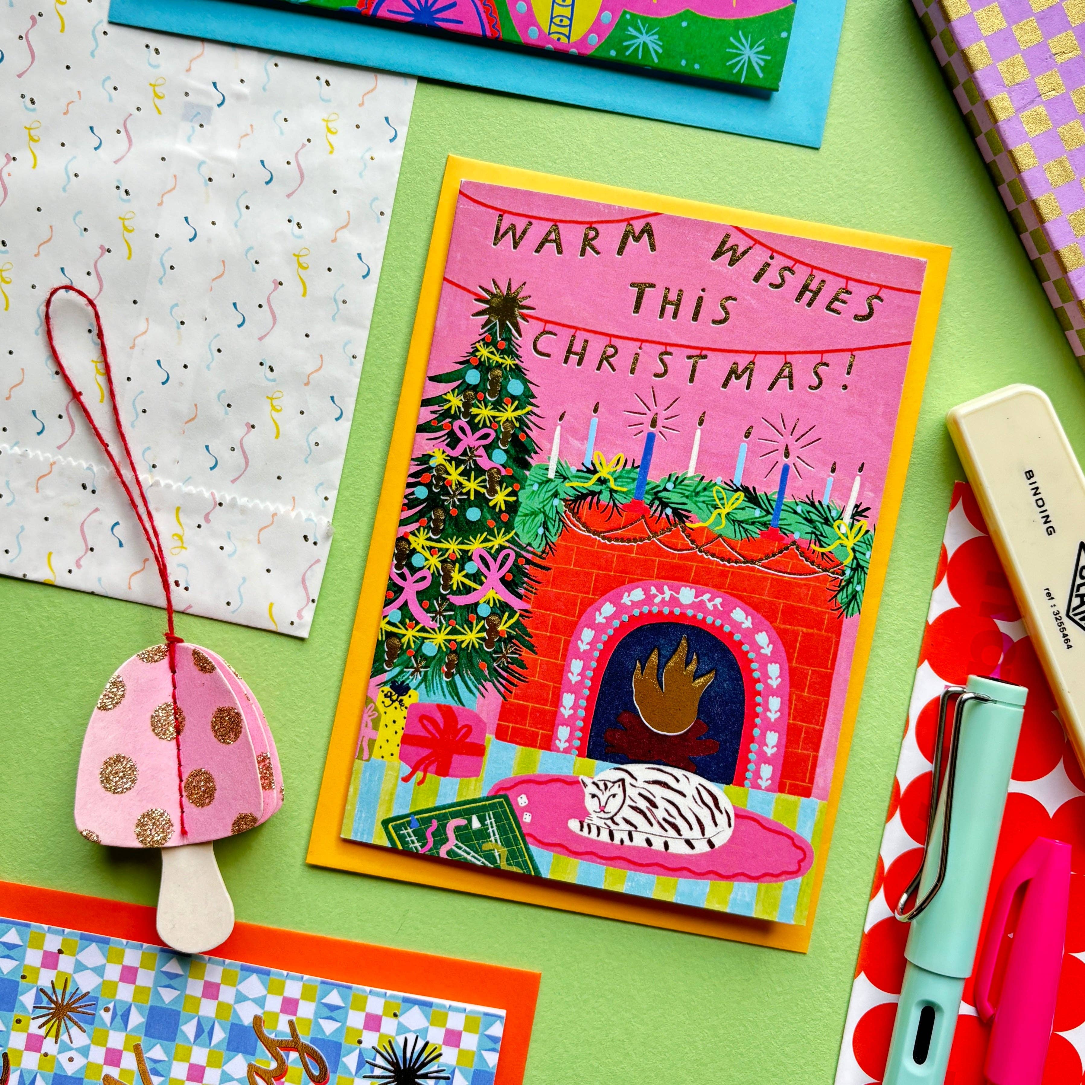 Kerrie Illustrates - Wholesale Christmas Card - Warm Wishes This Christmas Greeting Card | Fireplace Xmas Festive Greetings Cat Cozy Pink Gold Foil1