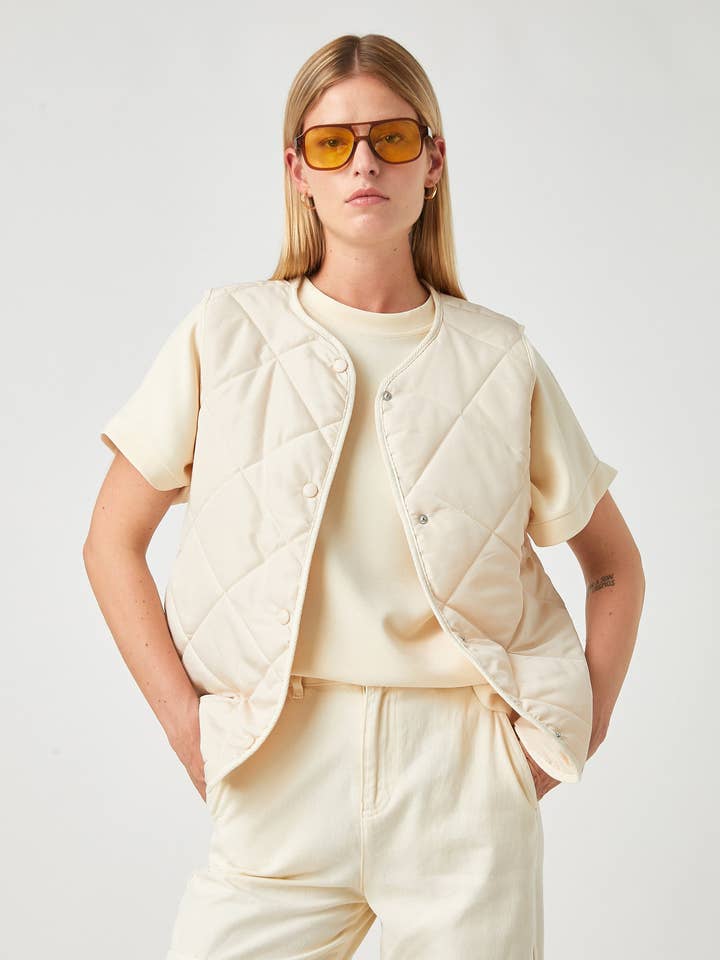 Dames crèmekleurige lichtgewicht gewatteerde bodywarmer met drukknoopsluiting voor wholesale door Usolo Outfitters