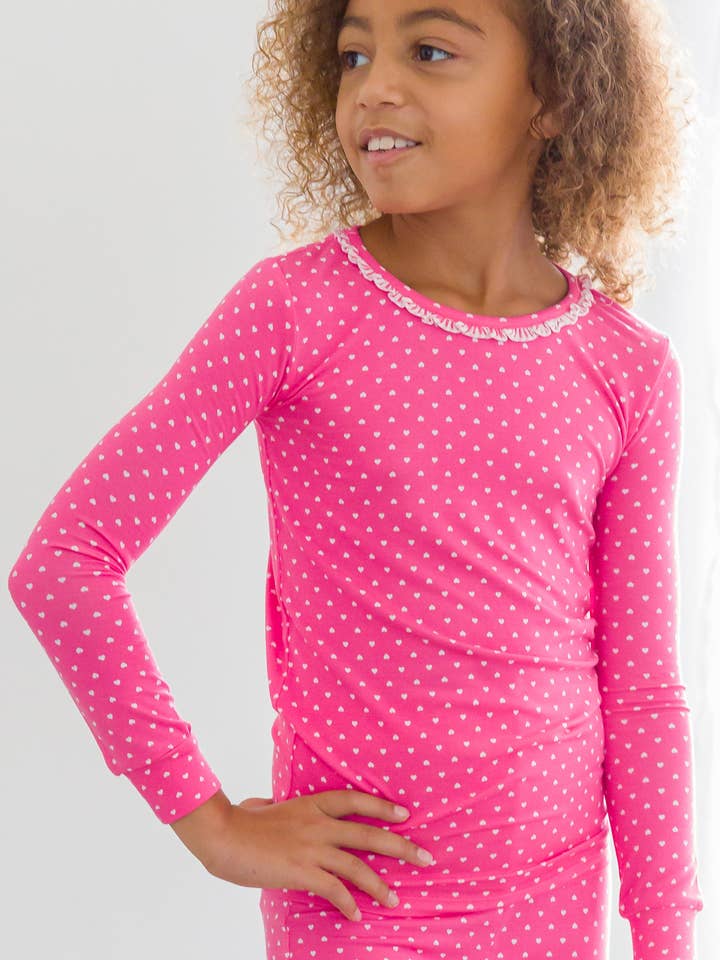 Conjunto de pijama de manga larga con volantes y estampado de corazones y lunares en color rosa intenso para niñas de SoftSnooze™ en viscosa de bambú. para venta al por mayor de RuffleButts + RuggedButts