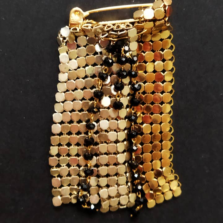 Broche i Paco Rabanne-stof med forskellige finish og bevægelige kædeender for engroshandel hos Rachel Ortiz