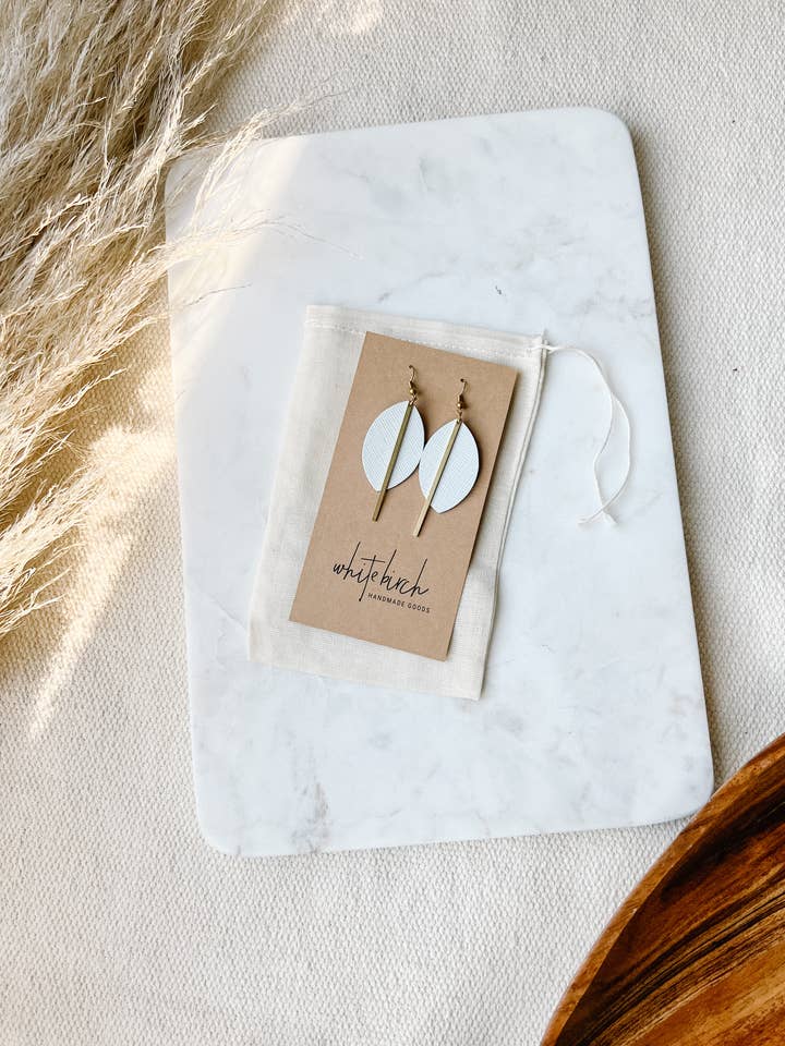 Örhängen i vit saffianoläder och mässing med kronbladform. för wholesale av Whitebirch Handmade Goods