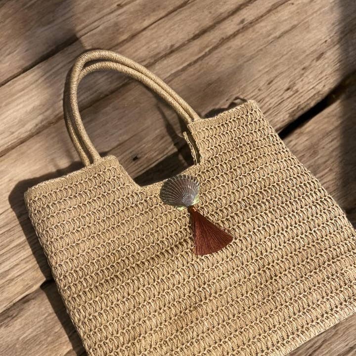 Geweven strandtas van stro met sint-jakobsschelp en boho kwastje voor wholesale door CC Shells Gifts LLC