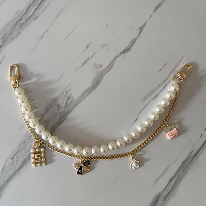 Gold CHAIN BAG CHARM-PEARL CHAIN BOW FLOWER PURSE | 40KC123 for wholesale on Faire