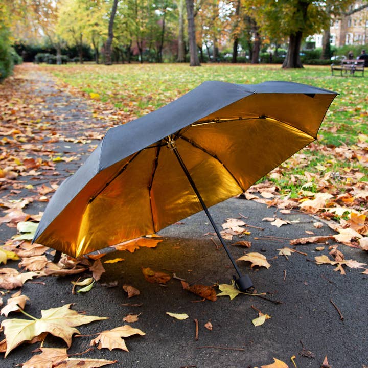 Paraguas compacto negro y dorado — Sol en un día lluvioso para venta al por mayor de SUCK UK