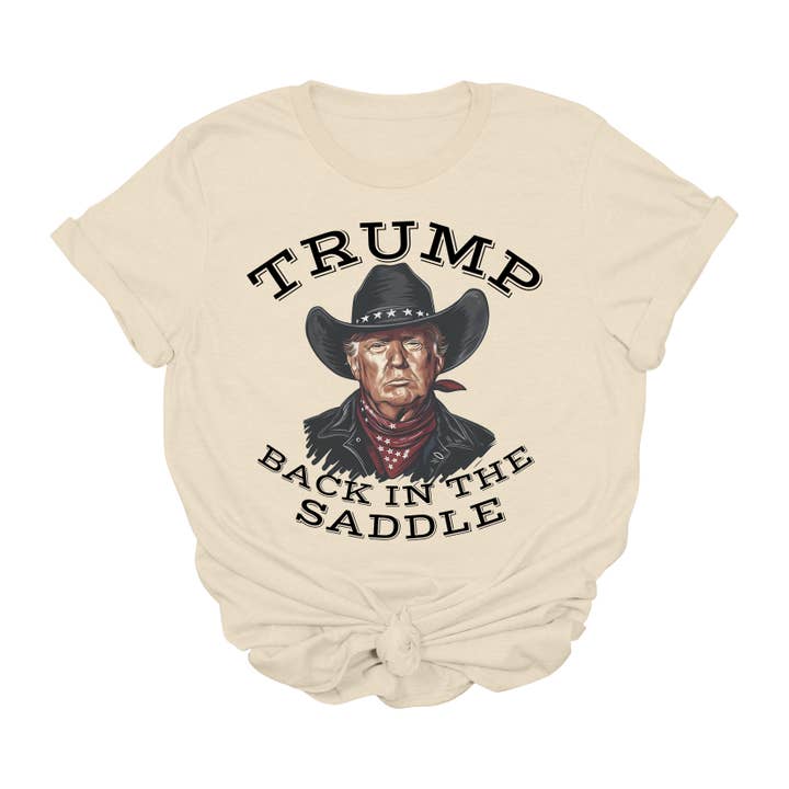Trump Terug in het Zadel T-Shirt | Cowboy Western Trump Grafisch T-Shirt | Politiek Comeback Shirt | Patriottische Conservatieve Kleding | Unisex USA T-Shirt voor wholesale door House of Savvy
