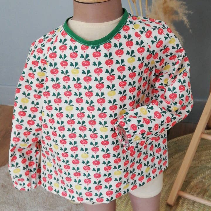 Bavoir à manches imperméable en coton enduit radis pour la vente par Miss et Cie