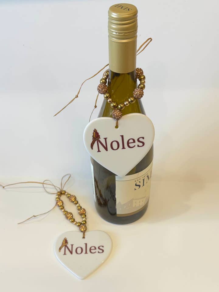 White Porcelain Heart Disk 3.5" Beverage Tag with the words Noles and a Spear for wholesale by Mona H Paintings