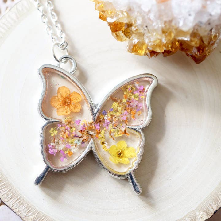 Collier papillon en argent orange, jaune et rose fleurs séchées en résine pour la vente par Ann + Joy